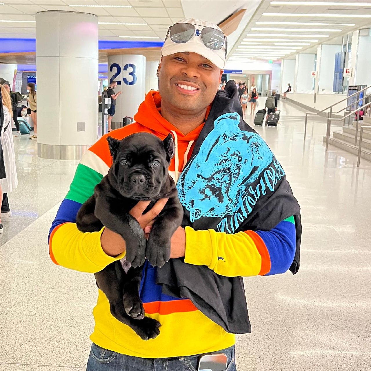 A buyer holding his black Cane Corso puppy at Dallas Fort Worth arrivals