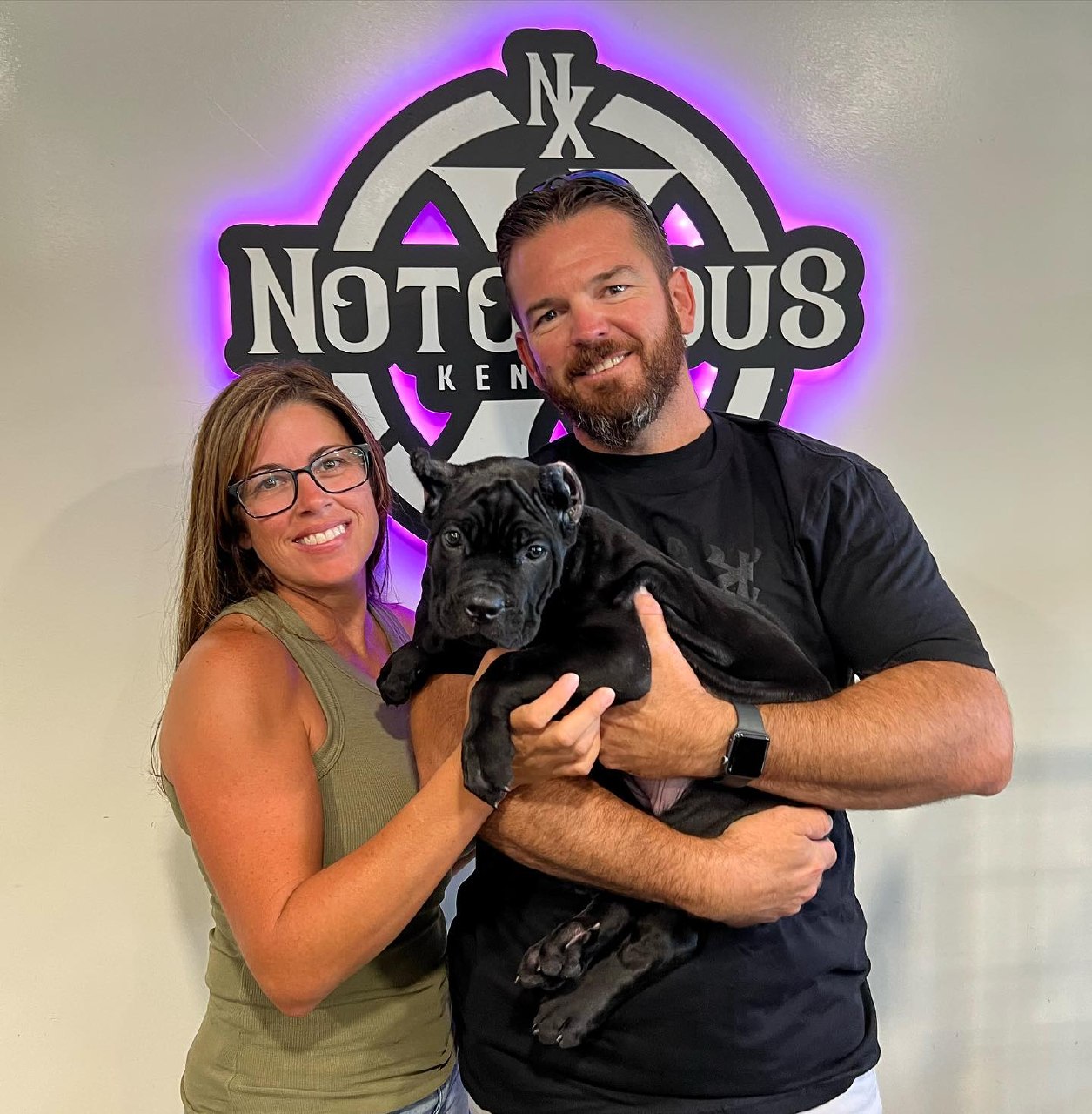 A couple collecting their black Cane Corso puppy from us in Riverside, California